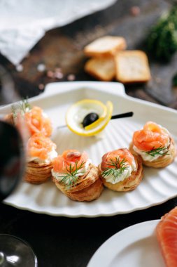 Somon ile puf pasta meze, Philadelphia peynir ve beyaz deniz kabuğu plaka üzerinde dereotu kırmızı şarap ile servis.