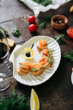 Somon ile puf pasta meze, Philadelphia peynir ve beyaz deniz kabuğu plaka üzerinde dereotu kırmızı şarap ile servis.