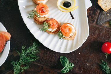 Somon ile puf pasta meze, Philadelphia peynir ve beyaz deniz kabuğu plaka üzerinde dereotu