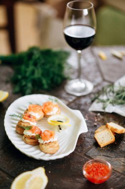 Somon ile puf pasta meze, Philadelphia peynir ve beyaz deniz kabuğu plaka üzerinde dereotu kırmızı şarap ile servis.