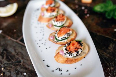 Somon, Philadelphia peyniri, salatalık ve siyah kimyon ile bruschettalar seti.