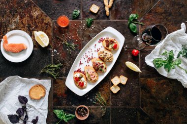 Tablo üzerinde şarap ve malzemeler ile servis edilen farklı Topingler ile bruschettalar seti