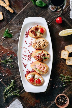 Tablo üzerinde şarap ve malzemeler ile servis edilen farklı Topingler ile bruschettalar seti