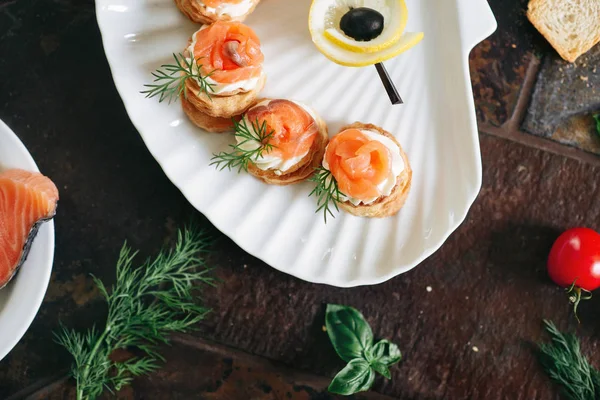 Somon ile puf pasta meze, Philadelphia peynir ve beyaz deniz kabuğu plaka üzerinde dereotu