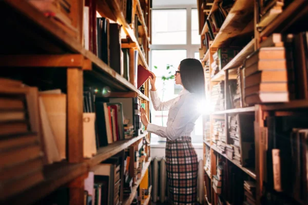 Kütüphanede kitap seçme genç kız