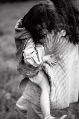 Kucağında kızı olan hippi bir annenin portresi. Aile birlikte eğleniyor.