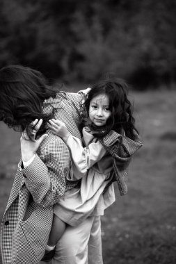 Kucağında kızı olan hippi bir annenin portresi. Aile birlikte eğleniyor.