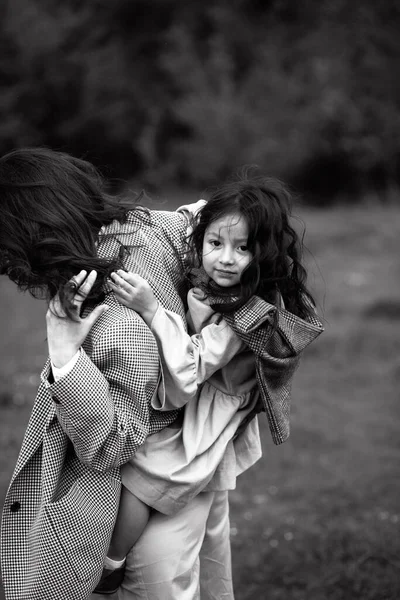 Kucağında kızı olan hippi bir annenin portresi. Aile birlikte eğleniyor.