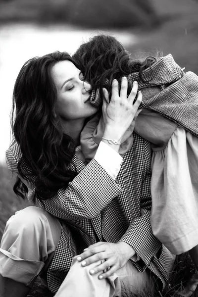 Tarz sahibi anne ve kız yağmur yağdığında nehir kenarındaki yeşil çimlerin olduğu bir arazide eğleniyorlar.