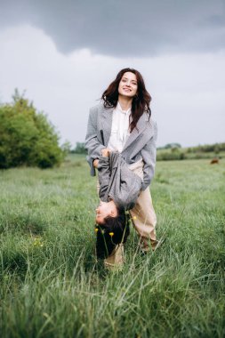 Annesiyle çimenlerde yatan kız yazın çok eğlenir.