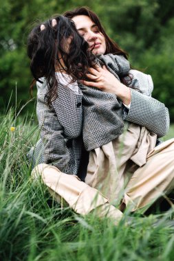 Tatil, seyahat şehveti, seyahat. Yeşil çimlerde kızı olan bir kadın. Aile, sevgi, güven. Anneler Günü konsepti dostum.