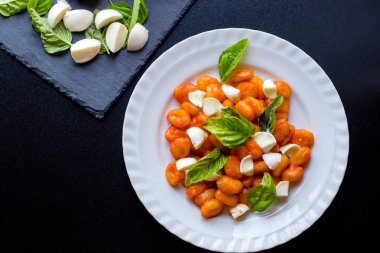 Gnocchi alla Sorrentina domates soslu Yeşil taze fesleğen ve mozzarella topları ile bir tabakta