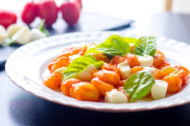 Gnocchi alla Sorrentina domates soslu Yeşil taze fesleğen ve mozzarella topları ile bir tabakta