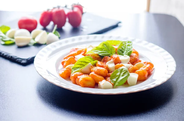 Gnocchi alla Sorrentina w sosie pomidorowym z zielone kule świeżą bazylią i mozzarellą podawane na talerzu — Zdjęcie stockowe