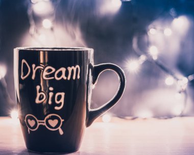 Kahve kupa ile harfler düş büyük bir ahşap üst ve Noel küçük ışıkları karanlık bir arka plan üzerinde buhar ile. Boşaltmak. Önden görünüm