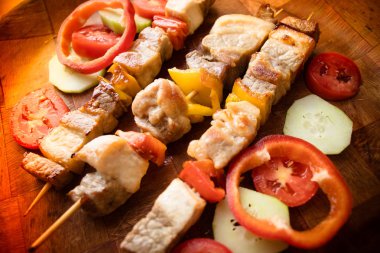 Sebzeli ızgara et parçaları. Mangalda şiş kebap veya şaşlık sopa üzerinde. Ahşap arka plan üzerinde üstten görünüm