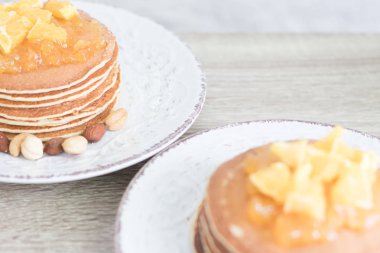 2 desenli tabak krep ve portakal reçeli ve ahşap masa arka plan üzerinde fındık ile beyaz. Portre. Boşaltmak