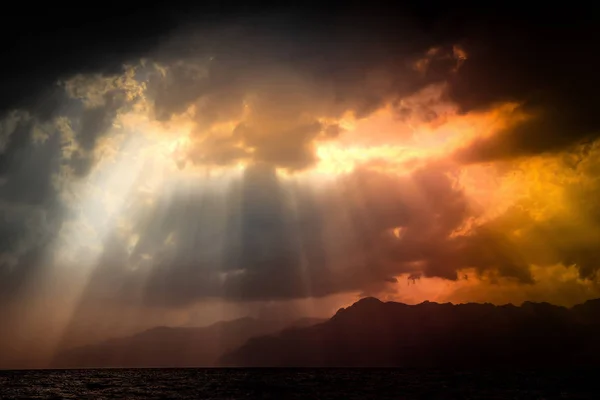 戏剧性的自然观。黑色的暴风雨天空在海面和山上, 阳光透过云层。意大利萨勒诺 — 图库照片