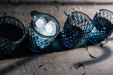 Ev barında soğuk bir şeyler içiyorum. Buz ve içecekle mavi geometrik bardaklar,