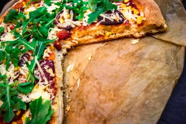 Arugula, parmesan peyniri ve kırmızı soslu lezzetli pizza hamuru.