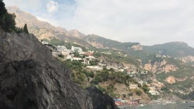 Positano manzaralı vahşi taş sahilden Tyhrrenian denizine, dağlarına ve yüksek keskin kayaları ve eski kulesi olan uçurumlara kadar manzaralı bir deniz manzarası. Amalfi Sahili, İtalya, Campania