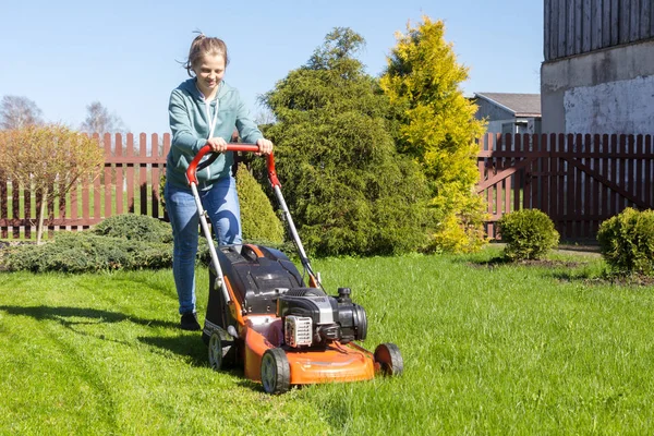 Tonårig flicka klipper gräs — Stockfoto