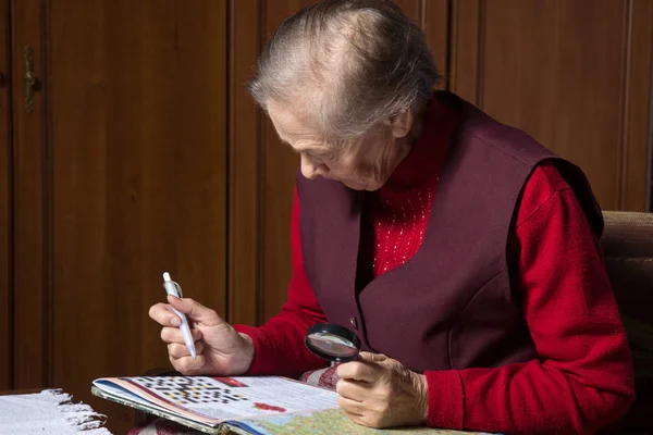 Old Woman Solves Crossword Puzzles Sitting Chair — Stock Photo, Image