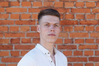 tuğla duvara karşı genç adam portresi