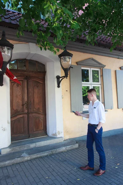 Mladý muž, který hledá velké dřevěné dveře — Stock fotografie