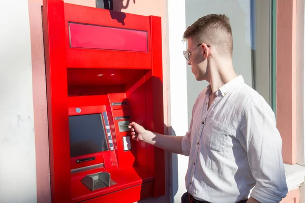 Jeune homme utilisant un distributeur automatique — Photo