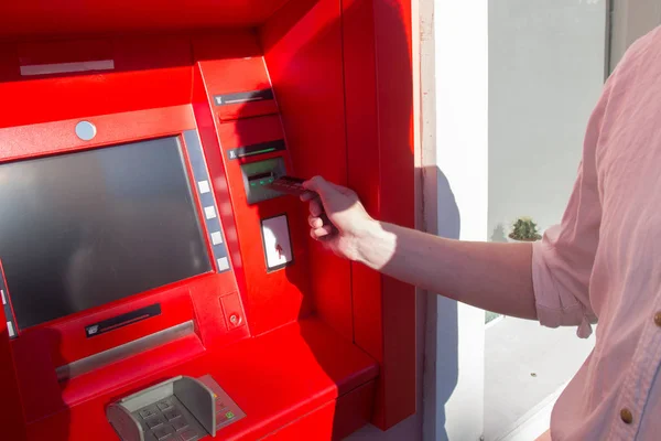Ruka muže s kreditní kartou, která používá bankomat. — Stock fotografie