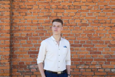 tuğla duvara karşı genç adam portresi