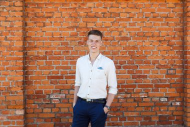 tuğla duvara karşı genç adam portresi