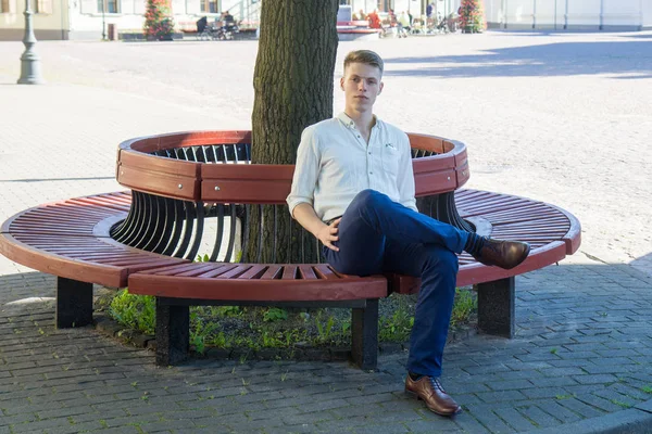 Joven sentado en un banco —  Fotos de Stock