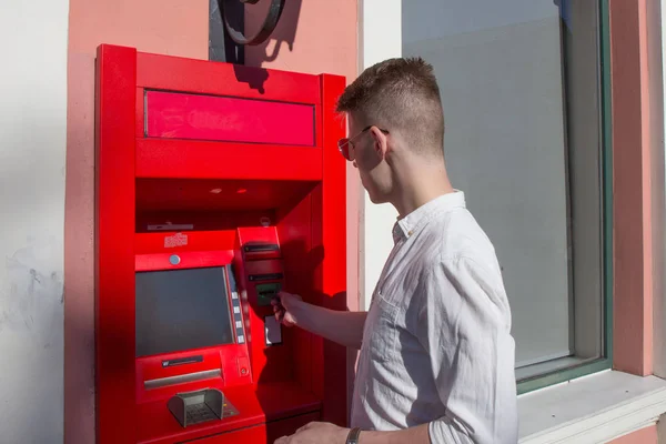 Jeune homme utilisant un distributeur automatique — Photo
