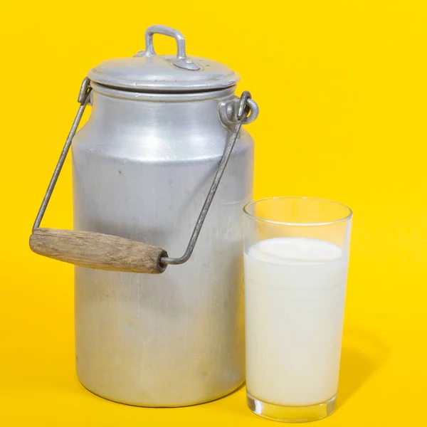 Стакан свежего молока и канистра с молоком — стоковое фото