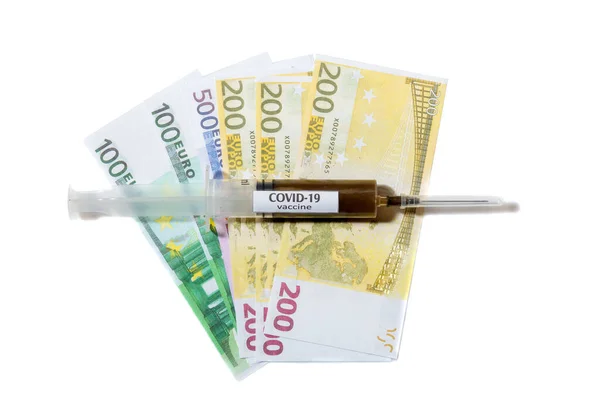 Vista ravvicinata dell'ago su una siringa riempita di vaccino posta su una banconota in euro — Foto Stock
