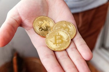 Adam elinde altın bitcoins para Cryptocurrency. Bankacılık web ve uluslararası ağ ödeme elektronik sanal para. Kripto para birimi sembolü