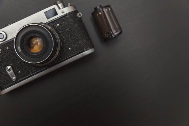 Saint-Petersburg, Rusya-1 Mart 2018: Vintage Film Kamera ve rulo üzerinde siyah ahşap arka plan teknoloji geliştirme fotoğrafçı kavramı kopya alanı ile. Üstten görünüm