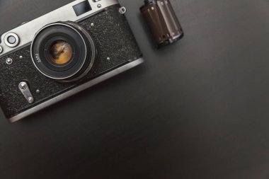 Saint-Petersburg, Rusya-1 Mart 2018: Vintage Film Kamera ve rulo üzerinde siyah ahşap arka plan teknoloji geliştirme fotoğrafçı kavramı kopya alanı ile. Üstten görünüm