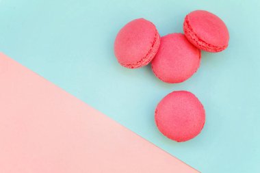 «Ana sayfa» mini pembe macaron veya acıbadem kurabiyesi Fransız tatlı pasta görünümünü yumuşak tatlı pembe ve mavi pastel geometrik üzerinde kağıt düz yatıyordu arka plan