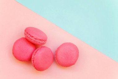 «Ana sayfa» mini pembe macaron veya acıbadem kurabiyesi Fransız tatlı pasta görünümünü yumuşak tatlı pembe ve mavi pastel geometrik üzerinde kağıt düz yatıyordu arka plan