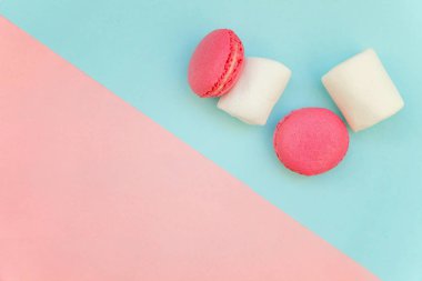 «Ana sayfa» mini pembe macaron veya marshmallow ile acıbadem kurabiyesi Fransız tatlı pasta görünümünü yumuşak tatlı pembe ve mavi pastel geometrik üzerinde kağıt düz yatıyordu arka plan