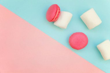 «Ana sayfa» mini pembe macaron veya marshmallow ile acıbadem kurabiyesi Fransız tatlı pasta görünümünü yumuşak tatlı pembe ve mavi pastel geometrik üzerinde kağıt düz yatıyordu arka plan
