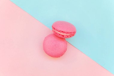«Ana sayfa» mini pembe macaron veya acıbadem kurabiyesi Fransız tatlı pasta görünümünü yumuşak tatlı pembe ve mavi pastel geometrik üzerinde kağıt düz yatıyordu arka plan