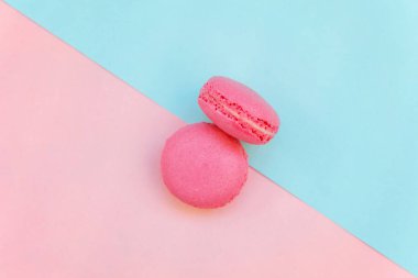 «Ana sayfa» mini pembe macaron veya acıbadem kurabiyesi Fransız tatlı pasta görünümünü yumuşak tatlı pembe ve mavi pastel geometrik üzerinde kağıt düz yatıyordu arka plan