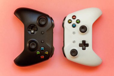 Saint-Petersburg, Rusya-13 Nisan 2018: siyah ve beyaz joystick xbox bir s gamepad, pembe bir arka plan üzerinde oyun konsolu. Bilgisayar oyun yarışması video oyunu denetim çatışma kavramı