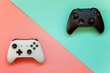 Saint-Petersburg, Rusya-13 Nisan 2018: siyah ve beyaz joystick xbox bir s gamepad, pembe ve mavi pastel renkli arka plan üzerinde oyun konsolu. Bilgisayar oyun yarışması video oyunu denetim çatışma kavramı