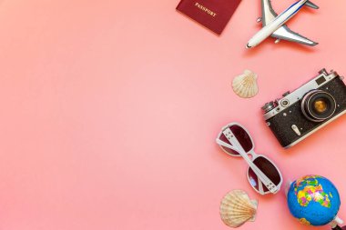 Çınar, bağbozumu kamera, pasaport, güneş gözlüğü, küre ve pembe renkli pastel trendy modern moda arka plan üzerinde kabuk ile düz yatıyordu. Tatil seyahat yaz hafta sonu deniz macera seyahat kavramı