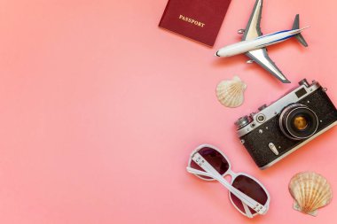 Çınar, bağbozumu kamera, pasaport, güneş gözlüğü ve pembe renkli pastel trendy modern moda arka plan üzerinde kabuk ile düz yatıyordu. Tatil seyahat yaz hafta sonu deniz macera seyahat kavramı